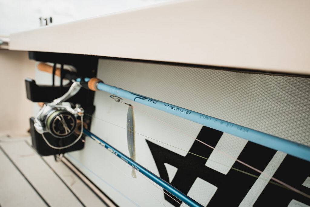Close-up of TFO IntraCoastal spinning rod secured on a boat with a lure rigged and ready for inshore fishing.