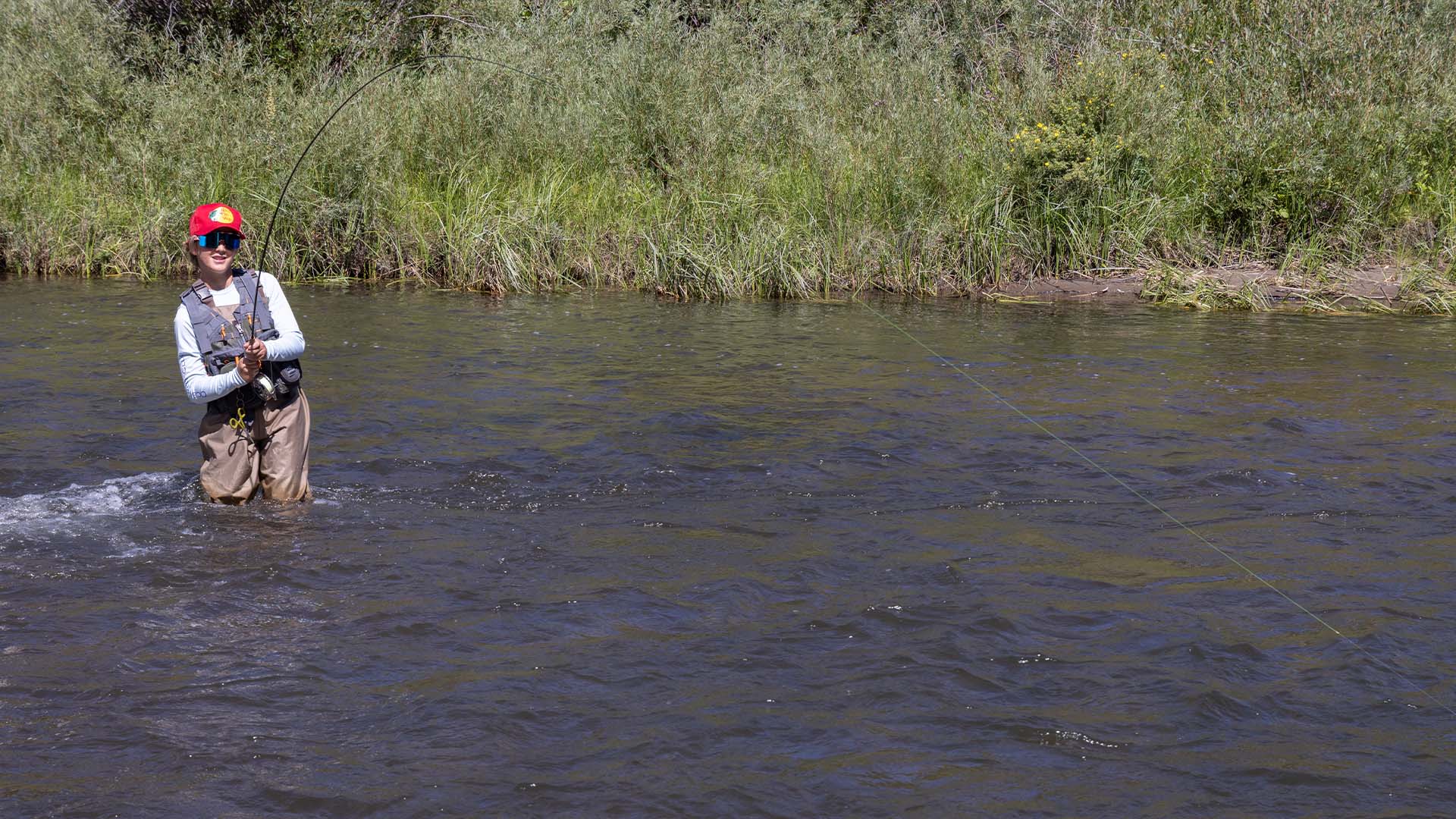 Young angler fighting a fish on the South Platte River during the TFO fly fishing school in Lake George, Colorado