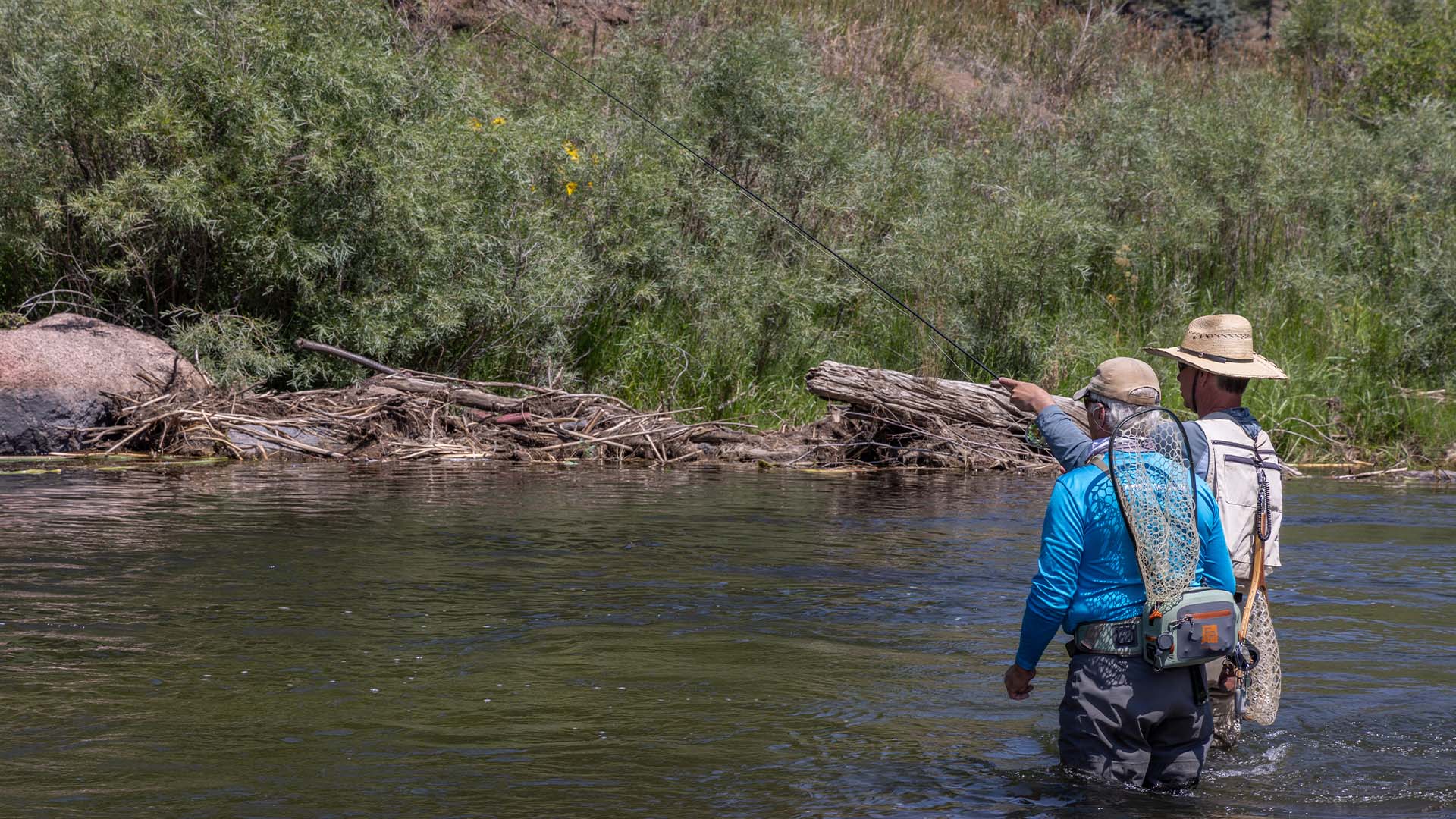 Jason Randall instructing an angler on euro nymphing techniques while wading the South Platte River during the TFO fly fishing school in Lake George, Colorado