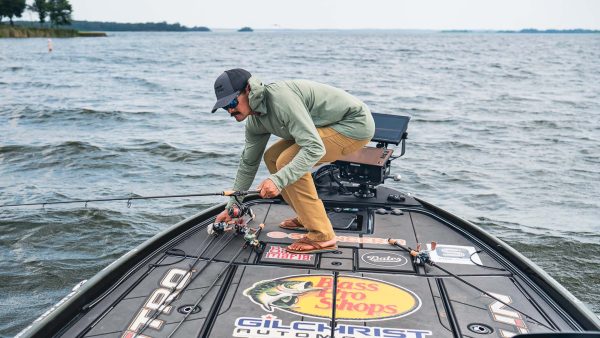 Angler selecting from a lineup of TFO Resolve rods rigged on a bass boat deck